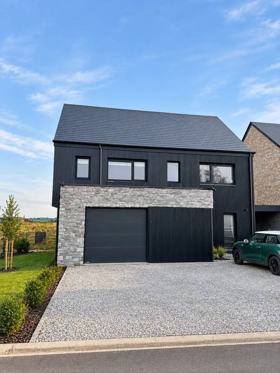 Maison contemporaine avec bardage sombre et pierre de parement Grès Rochefort